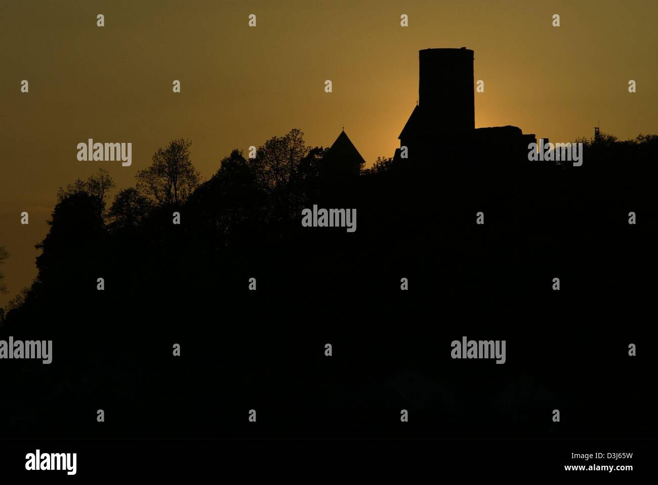 (Afp) - Le soleil se couche derrière le château de Nuerburg qui menace au-dessus de la course de Nürburgring en Allemagne, le 26 mai 2004. Le dimanche, 30 mai 2004 le Grand Prix de Formule 1 de l'Europe aura lieu à la célèbre course. Banque D'Images