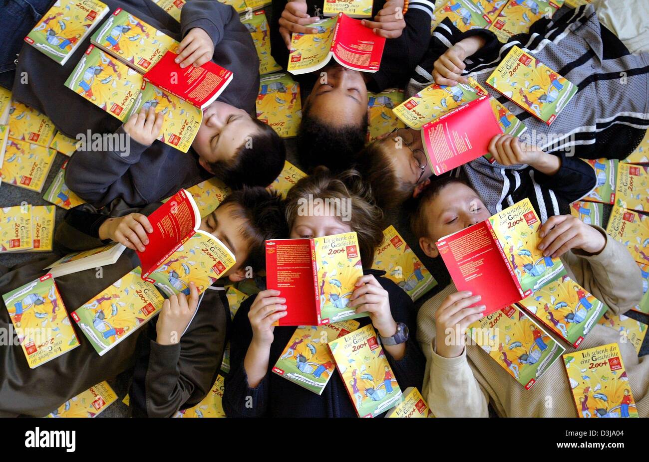 (Afp) - Un groupe de six étudiants de l'année s'allonger sur le dos et lire le livre "Ich schenk dir Eine Geschichte' (je vous présente une histoire) dans la bibliothèque de leur école à Mainz, Allemagne, 2 avril 2004. La lecture, en collaboration avec l'industrie du livre a produit le livre pour enfants à l'occasion de la Journée mondiale du livre 2004 de l'UNESCO et les distribuera aux enfants et un Banque D'Images