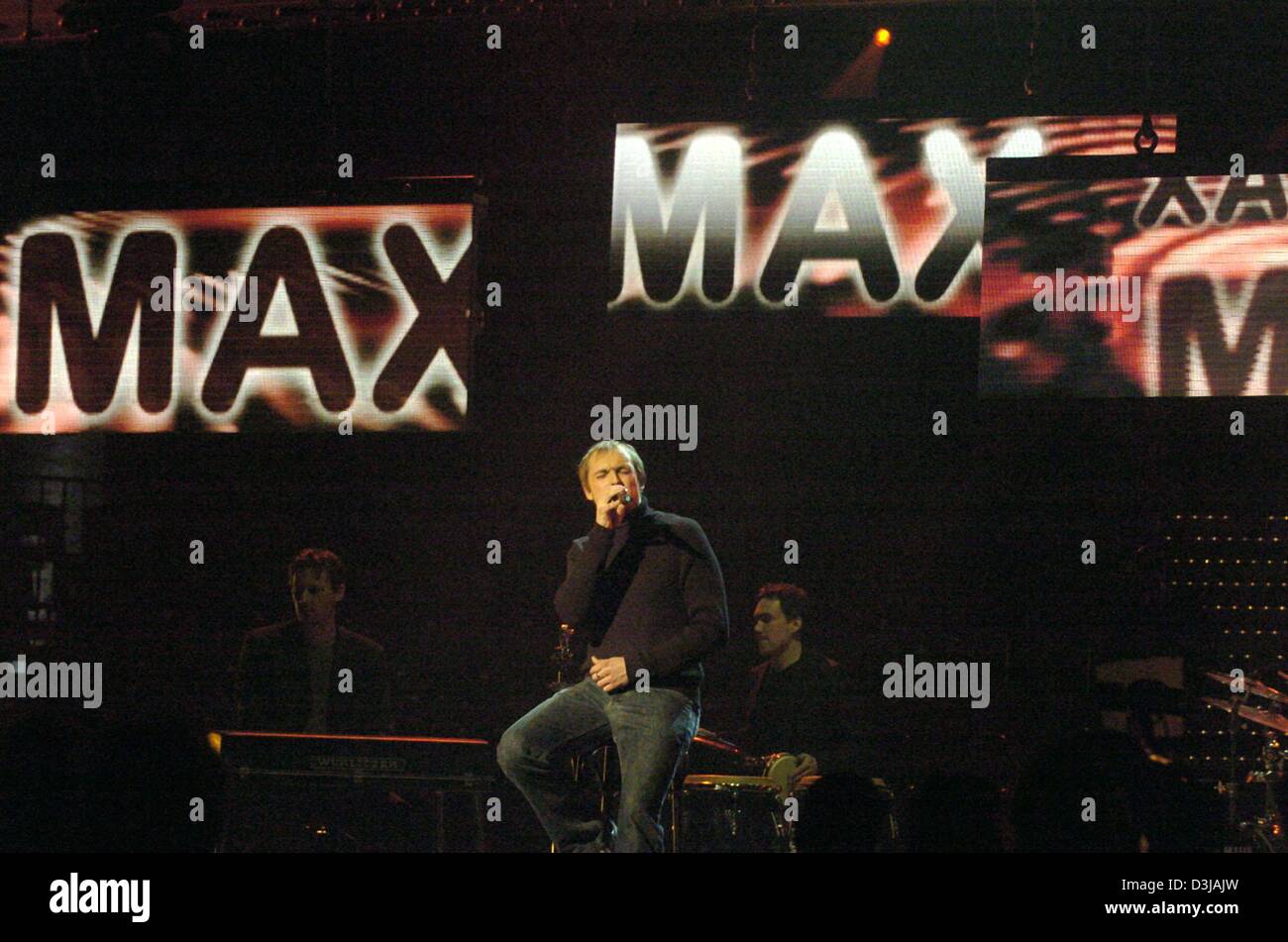 (Afp) - 22 ans, la chanteuse allemande Max est assis sur un tabouret, est titulaire d'un microphone à la main et effectue pendant la répétition générale pour le tour préliminaire de l'Allemand Eurovisions song contest à Berlin, 19 mars 2004. Le vainqueur de la ronde préliminaire va représenter l'Allemagne en finale de l'Eurovisions song contest à Istanbul, Turquie. Banque D'Images