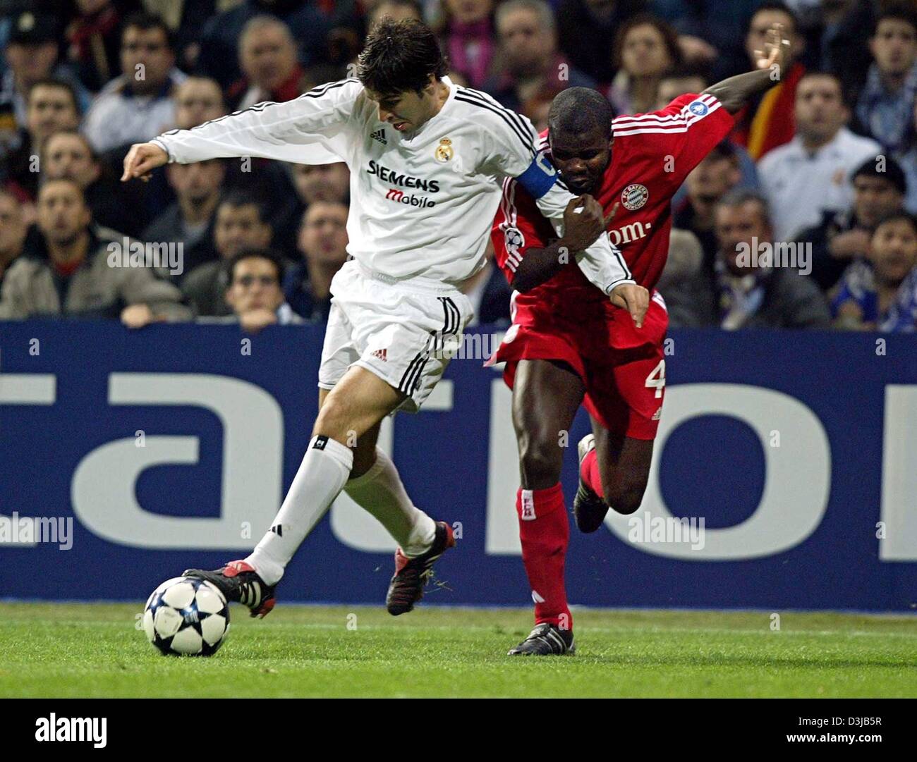 (Dpa) joueur du Real Madrid Raul (à gauche) et le FC Bayern Munich dvd Sammy Kufour lutte pour le ballon au cours de la Ligue des Champions finale match aller 1/8 seconde au Santiago Bernabeu-Stadium à Madrid le mercredi 10 mars 2004. Le Real Madrid a gagné 1:0 et passe à la ronde suivante. Banque D'Images