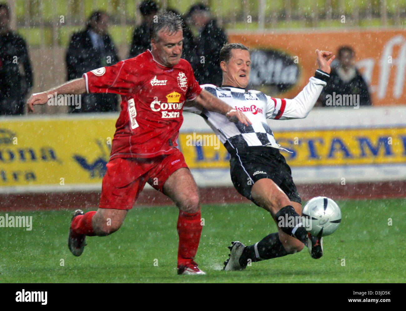 (Afp) - L'Allemand pilote de Formule 1 Michael Schumacher (R) de la Ferrari défis pour la balle dans un duel avec la légende du football français Didier Deschamps au cours d'un match de football de bienfaisance à Monte Carlo, Monaco, le mardi 17 mai 2005. Le Grand Prix de Formule 1 de Monaco aura lieu le dimanche 22 mai 2005. Banque D'Images