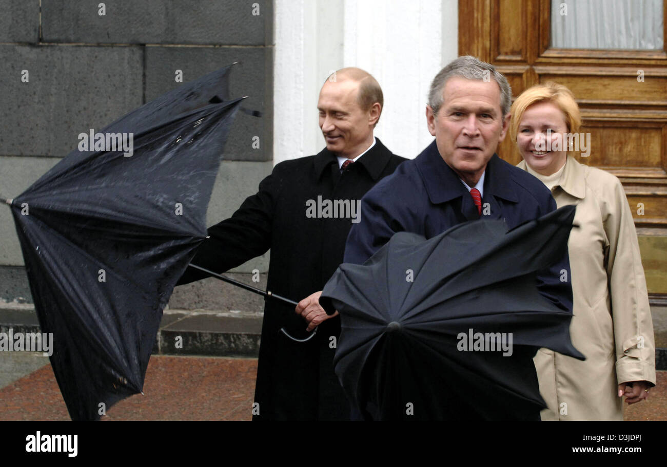 (Afp) - Le président américain George W. Bush et le président russe Vladimir Poutine (G) lutte avec thieer parapluies comme l'épouse Ludmila Poutine regarde et sourit au cours des célébrations commémorant le 60e anniversaire de la fin de la Seconde Guerre mondiale à Moscou, Russie, le lundi, 09 mai 2005. La Russie a célébré avec de nombreux invités chef de membres la victoire des Alliés sur l'Allemagne nazie. Banque D'Images