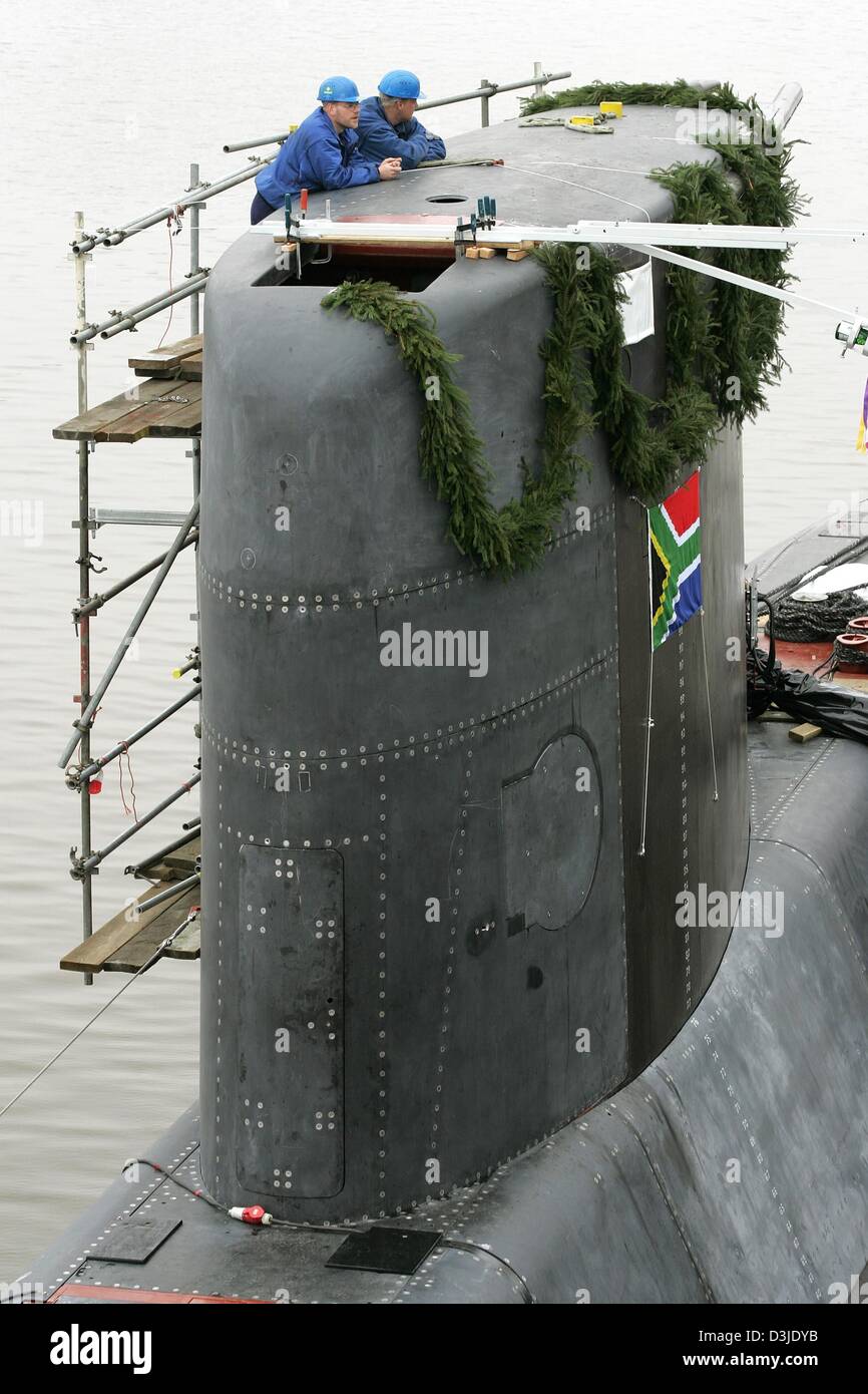 (Afp) - Deux travailleurs de l'entreprise chantier naval allemand Nordseewerke se tenir sur les nouveaux sous-marins construits pour South-Aftrica et suivez le baptême du navire sur le quai à Emden, en Allemagne, le mercredi 04 mai 2005. Les 62 mètres de long est alimenté par un sous-marin diesel-électrique combiné-moteur et sera utilisé principalement en surveillance sous-marine sur la côte de l'Afrique du Sud. L'submarin Banque D'Images