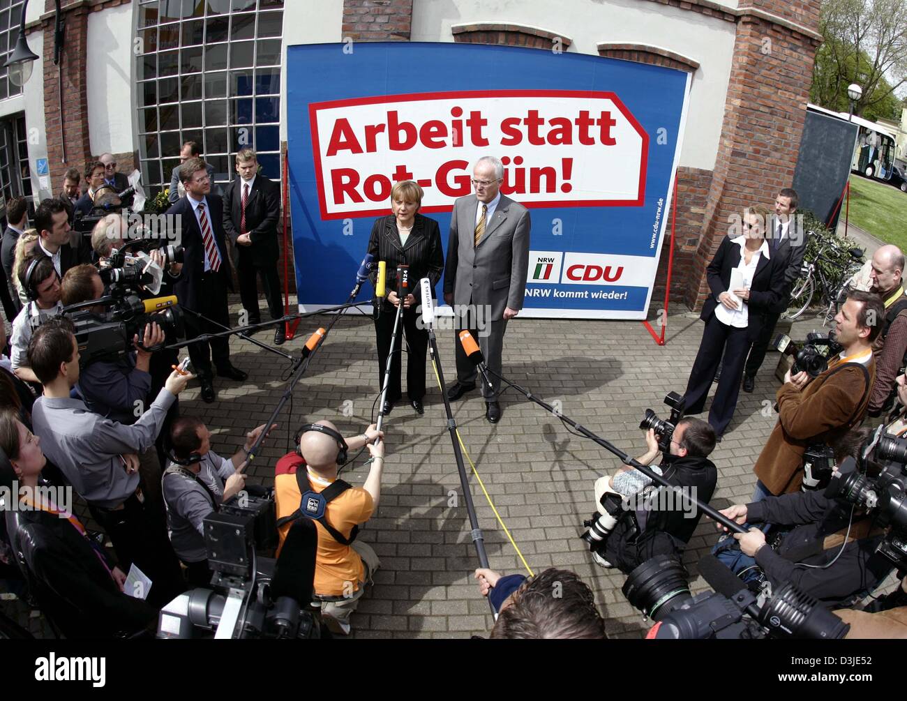 (Afp) - Angela Merkel (L), Présidente de la CDU et Juergen Ruettgers, Président de la CDU dans l'état de Rhénanie du Nord-Westphalie et la CDU est le premier candidat pour la prochaine élection d'état, sont devant une affiche électorale comme ils parlent aux représentants des médias au cours de la soi-disant "Congrès de l'Innovation' à Gelsenkirchen, Allemagne, le jeudi 28 avril 2005. L'affiche indique 'W Banque D'Images