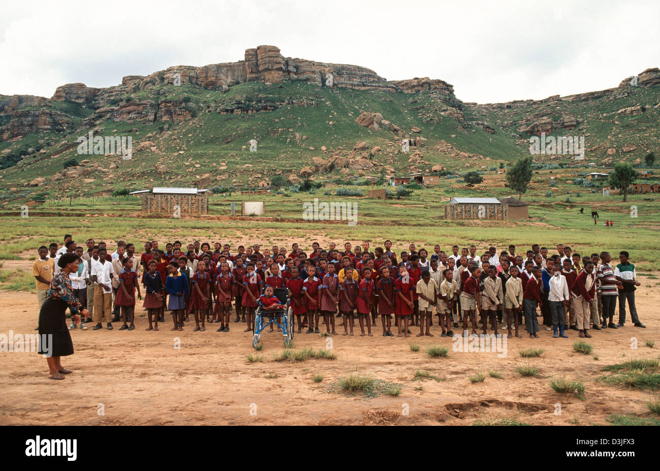 Les écoliers se exécutant à l'extérieur d'une école rurale pour accueillir les visiteurs, Matsieng. Lesotho Banque D'Images