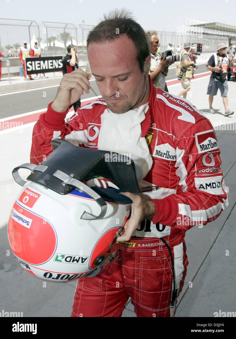 (Afp) - pilote de Formule 1 brésilien Rubens Barrichello (Ferrari) retourne à son puits après qu'il n'a pas réussi à démarrer pour la deuxième qualification pour le Grand Prix de Bahreïn à la formule une piste près de Manama, Bahreïn, le 3 avril 2005. Banque D'Images