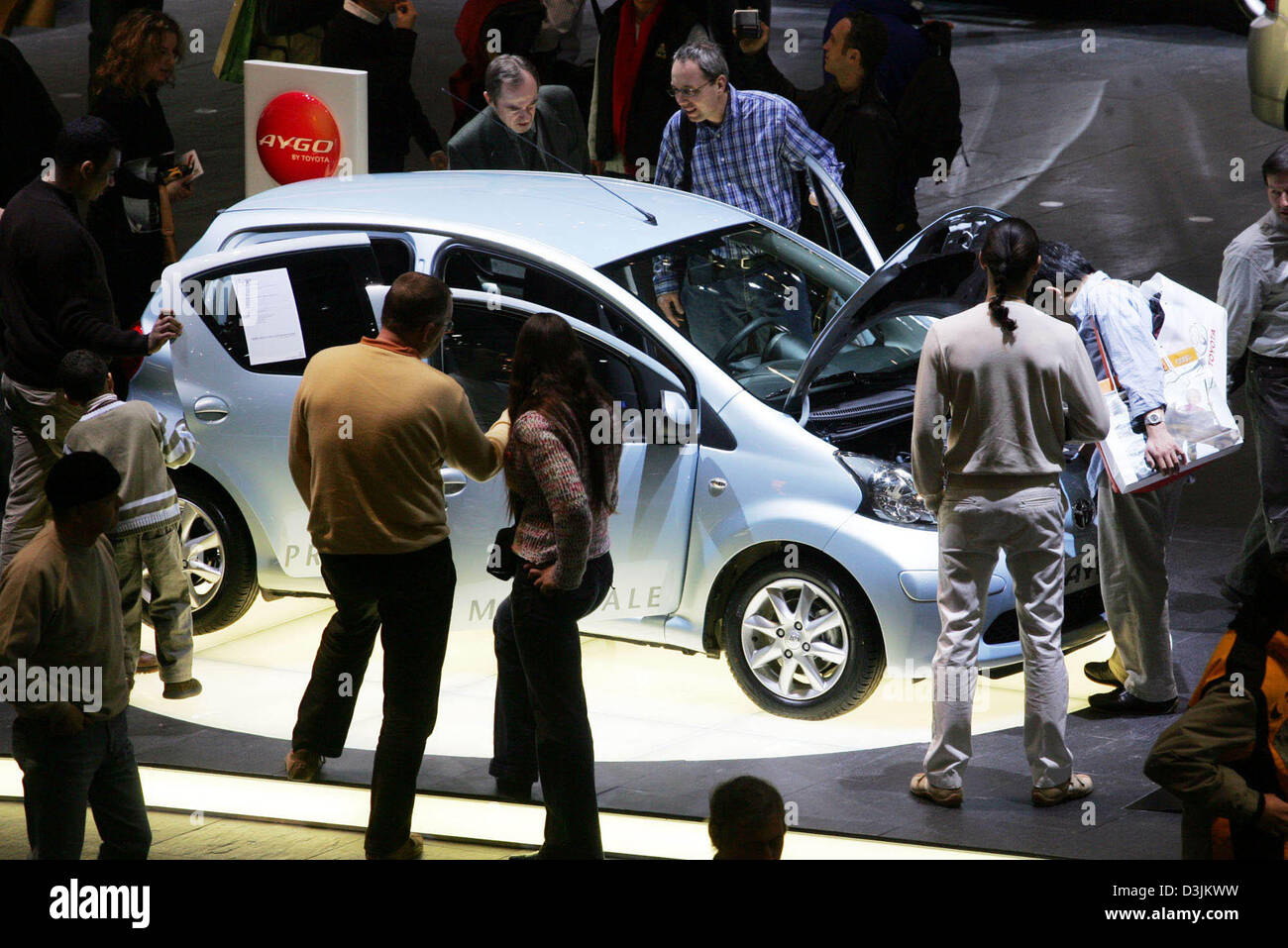 (Afp) - Les visiteurs de l'exposition de voiture découvrez la nouvelle Toyota Aygo à Genève, Suisse, 3 mars 2005. La voiture vient d'un projet conjoint Japonais Français et est basée sur la même technologie que la Peugeot 107 et la Citroën C1. Les visiteurs ont pu voir les nouveautés des constructeurs de voitures entre 3 mars et 13 mars 2005. Banque D'Images