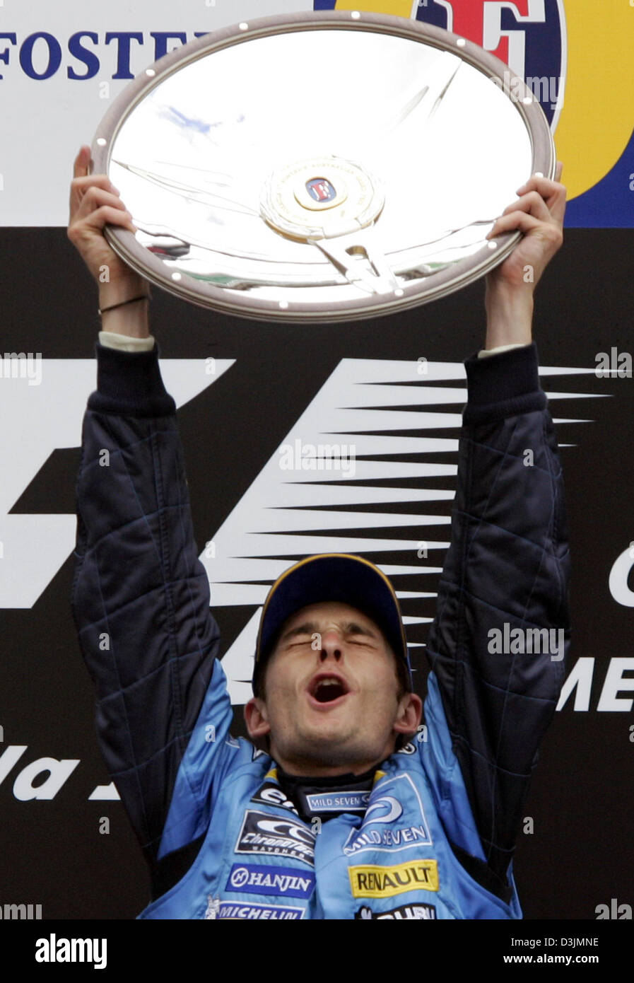 (Afp) - pilote de Formule 1 Italien Giancarlo Fisichella (Renault) contient jusqu'son trophée et jubilates sur le podium après avoir remporté le Grand Prix d'Australie à Melbourne, Australie, 06 mars 2005. Fisichella a remporté l'avant du pilote brésilien Rubens Barrichello et Fernando Alonso, de l'Espagne. Banque D'Images