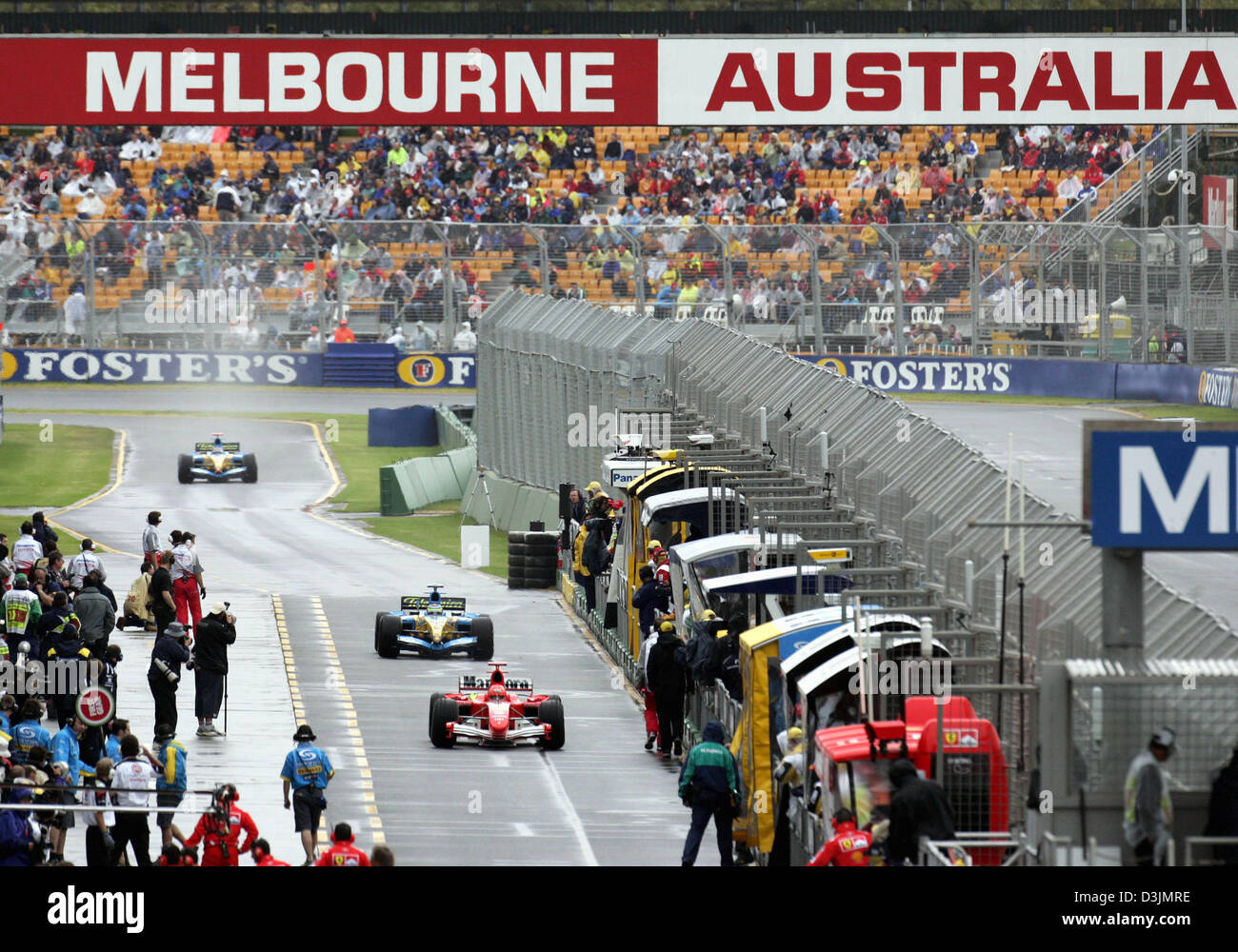 (Afp) - L'Allemand pilote de Formule 1 Michael Schumacher (Ferrari), bas et d'autres conducteurs conduisent leurs voitures de course pendant la session de pratique à travers les stands sur le circuit du Grand Prix de l'Albert Park, Melbourne, Australie, 05 mars 2005. Banque D'Images