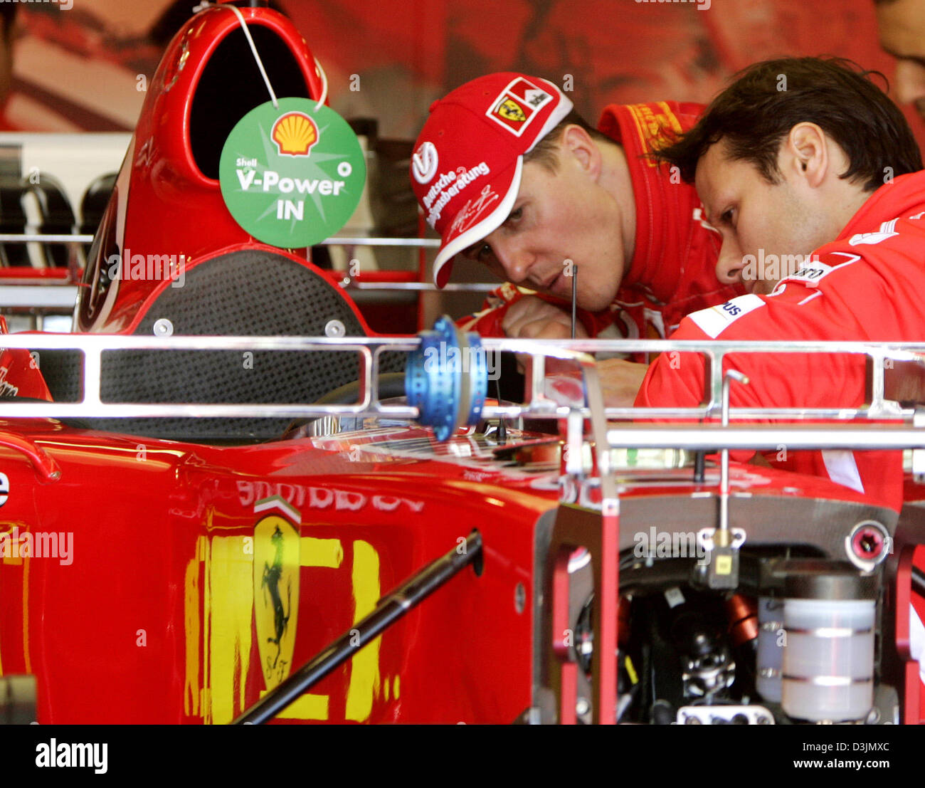 (Afp) - L'Allemand pilote de Formule 1 Michael Schumacher (Ferrari) de l'équipe parle à son chef mécanicien sur le circuit du Grand Prix de l'Albert Park à Melbourne, Australie, 3 mars 2005. Le premier Grand Prix de la saison 2005 débutera le dimanche 06 mars 2005. Banque D'Images