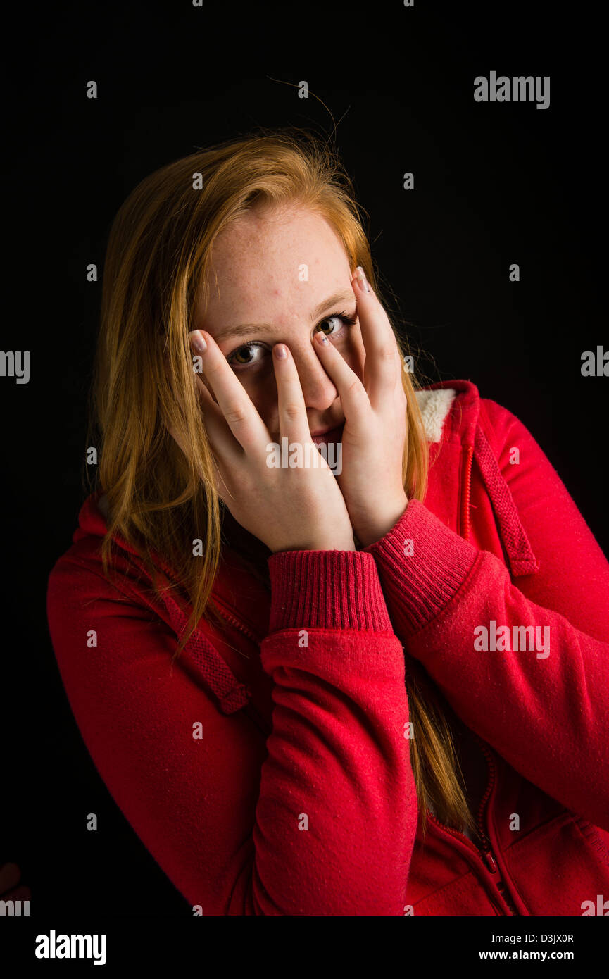Un timide 16 nerveux, 17 ans, aux cheveux rouges de rousseur face adolescente, UK Banque D'Images