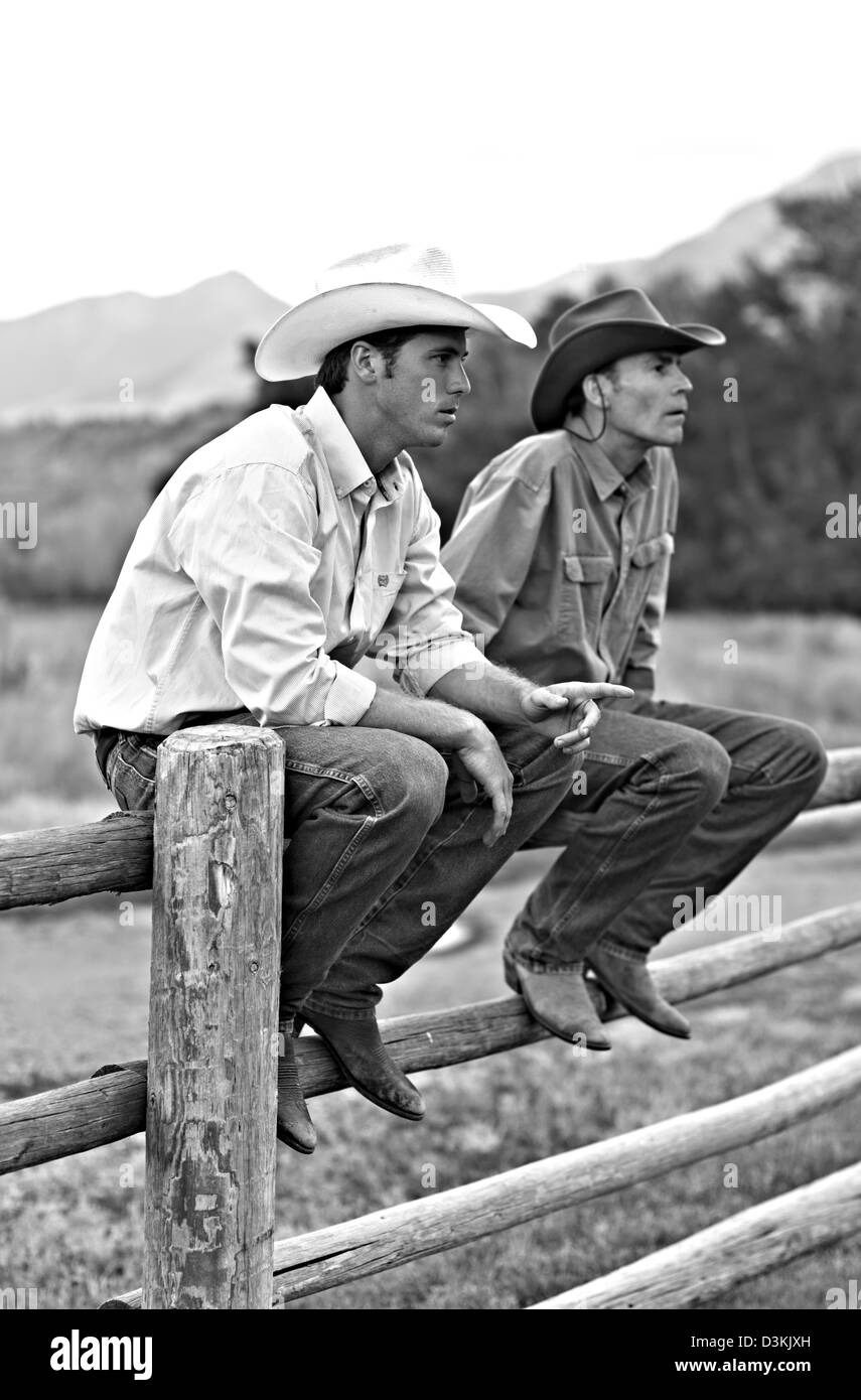 Les cow-boys s'asseoir sur la clôture ranch, Montana, USA Banque D'Images