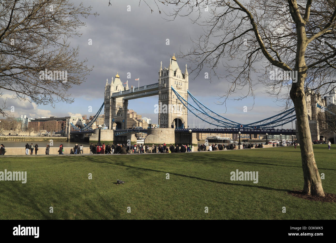 Les touristes se promener le long de l'Aragon à côté de Tower Bridge sous le soleil d'hivers jour Londres Angleterre Royaume-uni GB Banque D'Images