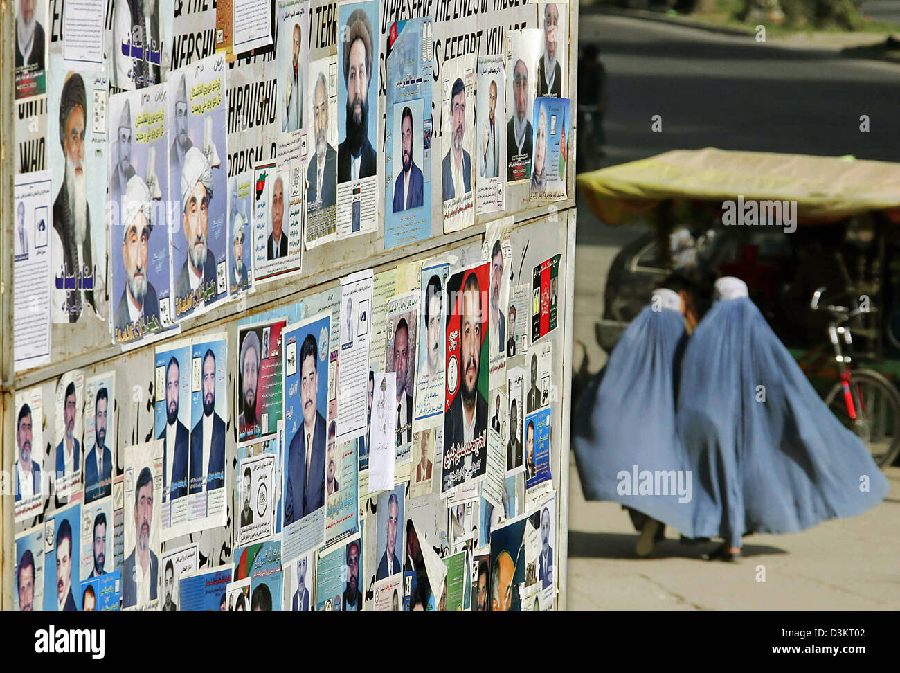 (Afp) - Deux femmes voilées passent un mur couvert d'affiches électorales à Kaboul, Afghanistan, le 24 août 2005. Le 18 septembre 2005, parlementaires et provinciales sont prévues en Afghanistan. Photo : Michael Hanschke Banque D'Images