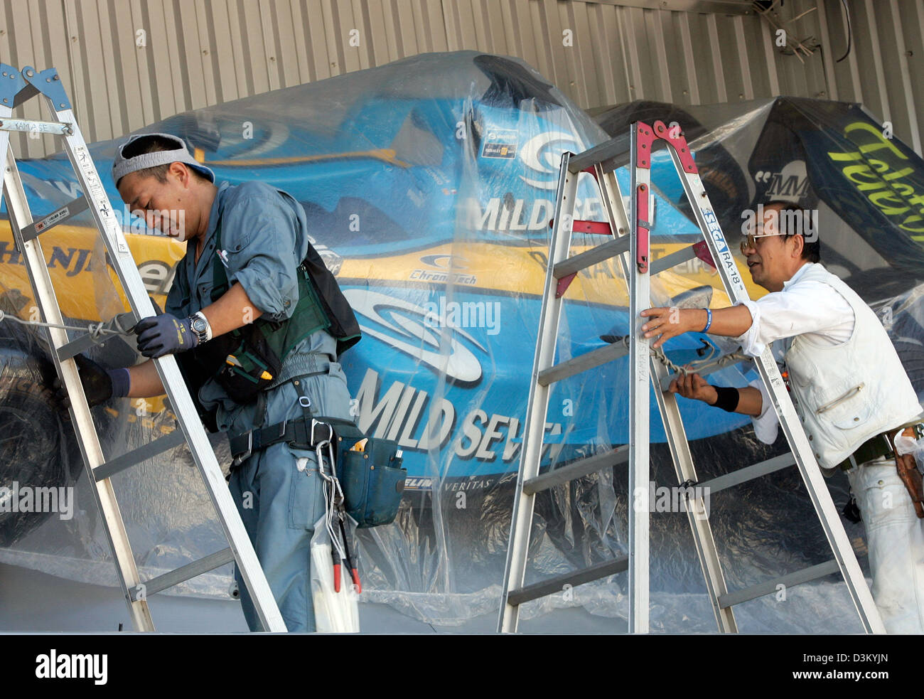 (Afp) - Les travailleurs de la construction mise en place d'un stand de publicité avec une réplique d'une voiture de sport à Renault F1 voie les Japonais à Suzuka, Japon, jeudi, 06 octobre 2005. Le Grand Prix du Japon aura lieu à Suzuka Dimanche 09 octobre. Photo : Gero Breloer Banque D'Images