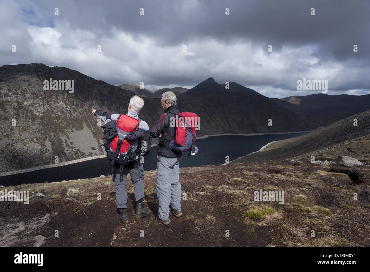 Deux marcheurs à l'ensemble du réservoir Ben Crom des pistes de Slieve Lamagan. Les montagnes de Mourne, comté de Down, Irlande du Nord. Banque D'Images