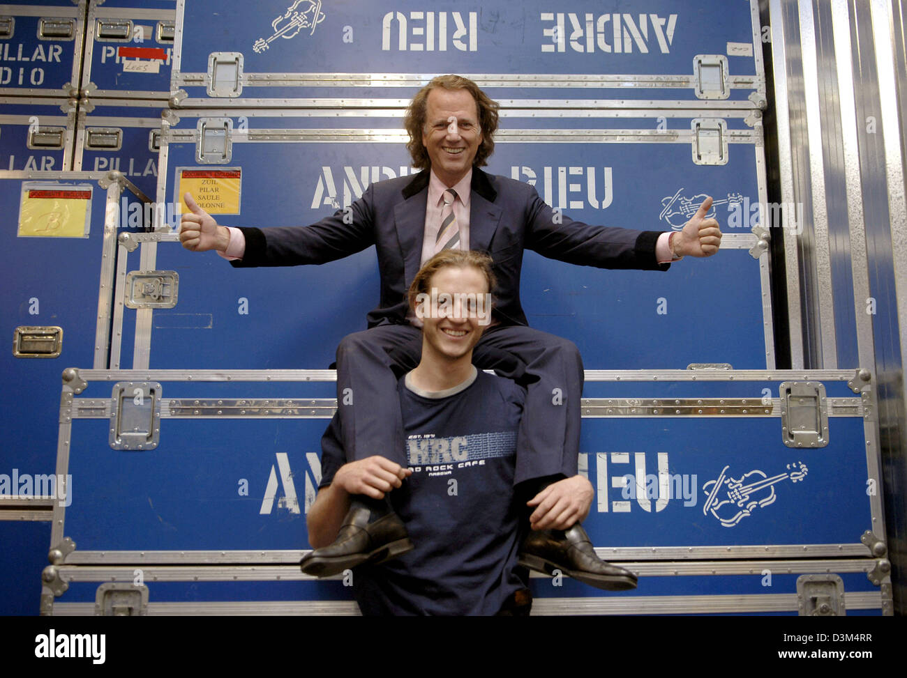 (Afp) - violoniste néerlandais André Rieu star (en haut) et son fils Pierre (24) posent devant de grands conteneurs avec André Rieu son nom à son entrepôt à Maastricht, aux Pays-Bas, 02 novembre 2005. Le 56-year-old musicien est sur le point de commencer la première partie de sa tournée à travers le Canada et les États-Unis, où il se produira au maire 13 villes. L'ensemble de l'équipement de son équipage, qui num Banque D'Images