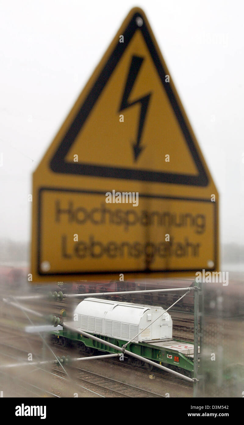 (Afp) - La photo montre un train avec 12 conteneurs de déchets nucléaires Castor et un signe avec l'inscription 'Hochspannung Lebensgefahr" (haute tension, danger de vie) à la gare de Woerth, Allemagne, 20 novembre 2005. (Photographiée par un panneau en Plexiglas, qui avaient été gelés et a partiellement décongelé). Le transport de déchets nucléaires a quitté le français r Banque D'Images