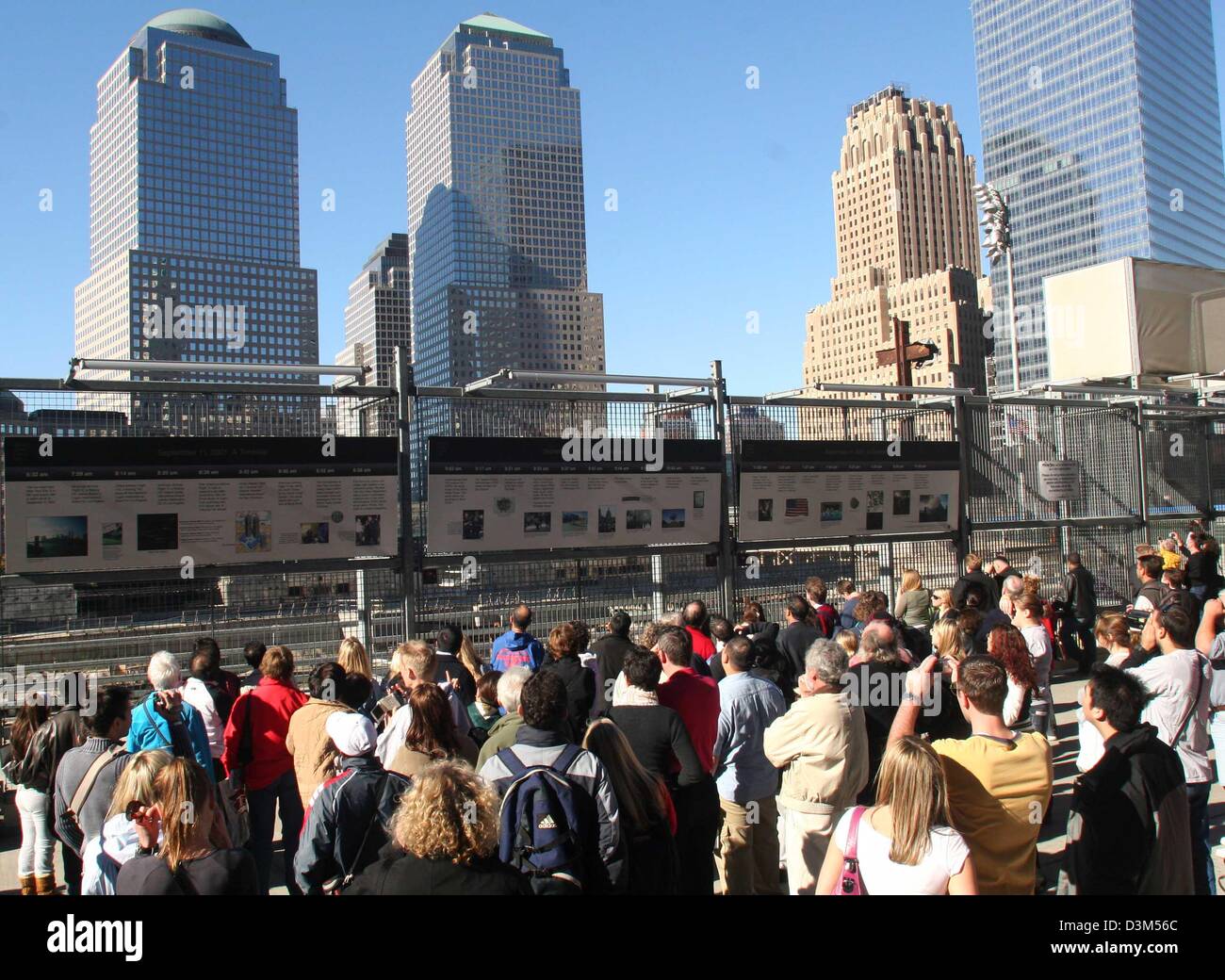 (Afp) - Les touristes regarder repasser doté d'une documentation de la terreur qui a eu lieu le 11 septembre 2001 devant le site de construction du Ground Zero à Manhattan dans l'extrémité sud de New York, USA, 07 novembre 2005. Le World Financial Center peut être vu dans l'arrière-plan. Ici, où une fois utilisés pour supporter le World Trade Center qui a été détruit au cours des attaques de Banque D'Images