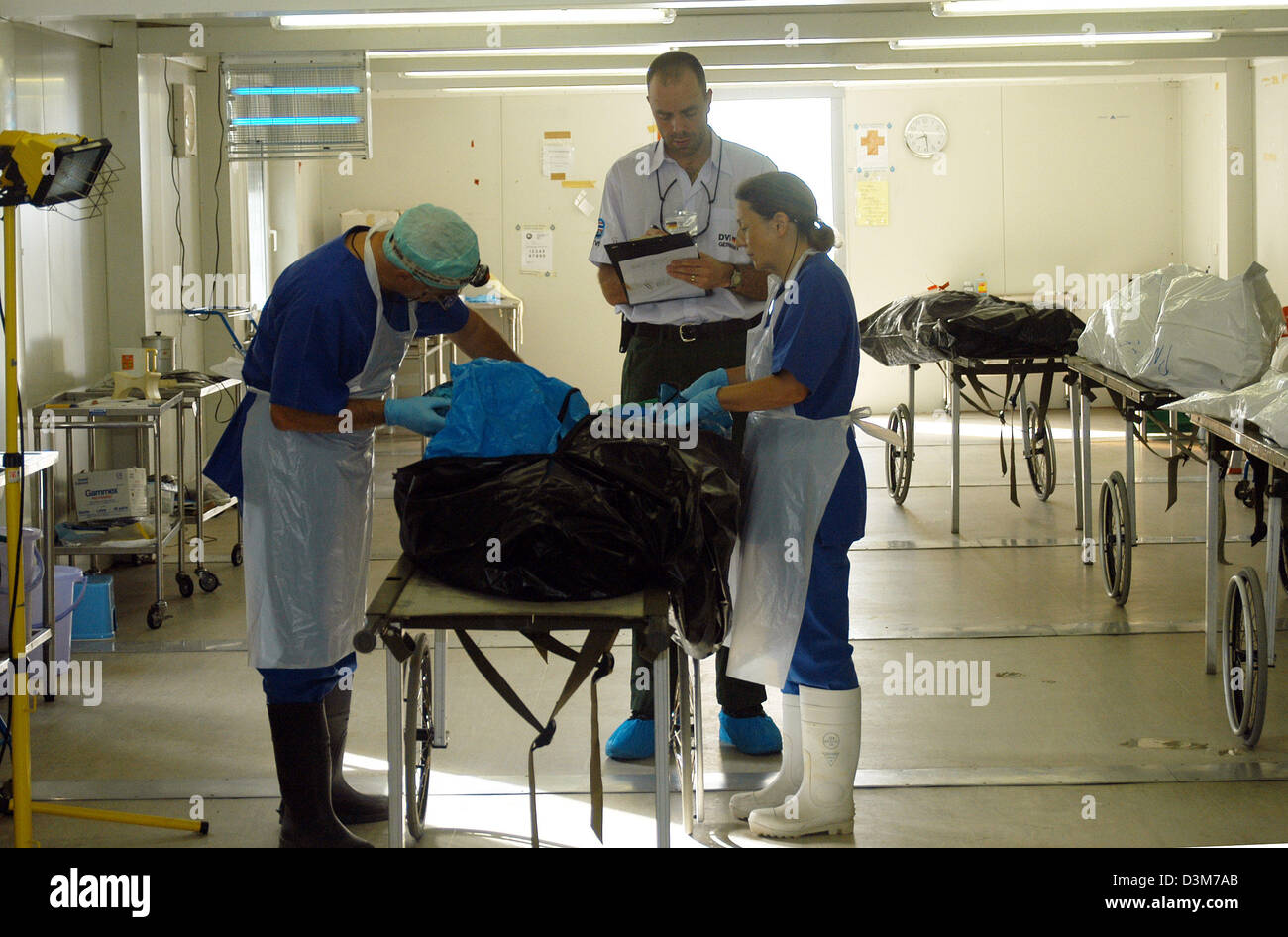 (Afp) - Médecin légiste allemand Ruediger Lessig (C) et ses collègues (nom inconnu) Examiner une victime du tsunami pour matériel ADN sur l'île de Phuket, Thaïlande, le 10 décembre 2005. 47 ans Lessig termine son service sur place près d'un an après la catastrophe du tsunami dévastateur en Asie du Sud est le mercredi, 14 décembre 2005. Le médecin légiste de Leipzig est commi Banque D'Images