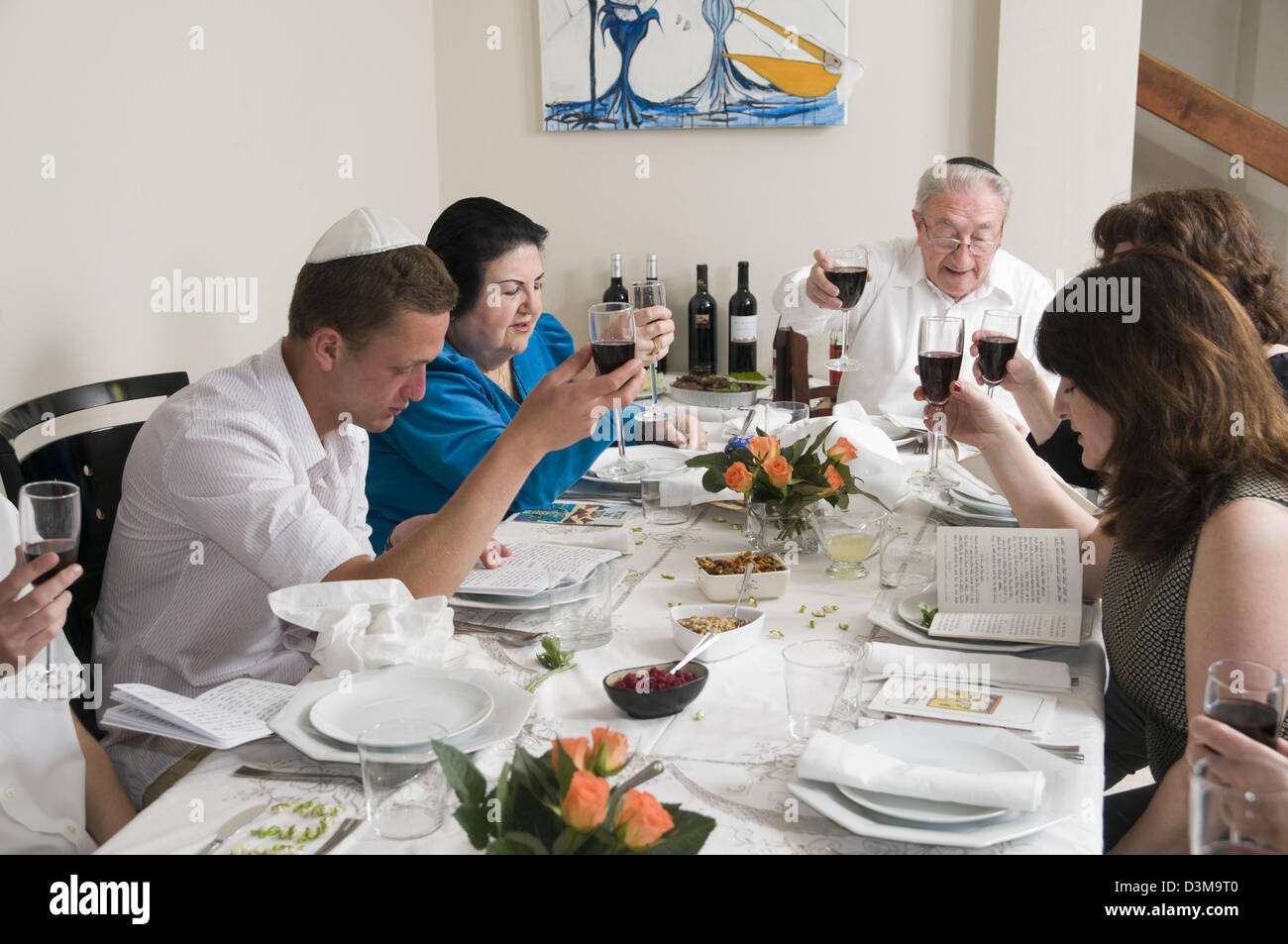 Famille assis autour d'une table pour un repas de fête juive sur la Pâque (Pessa'h, ou Pessah) Banque D'Images