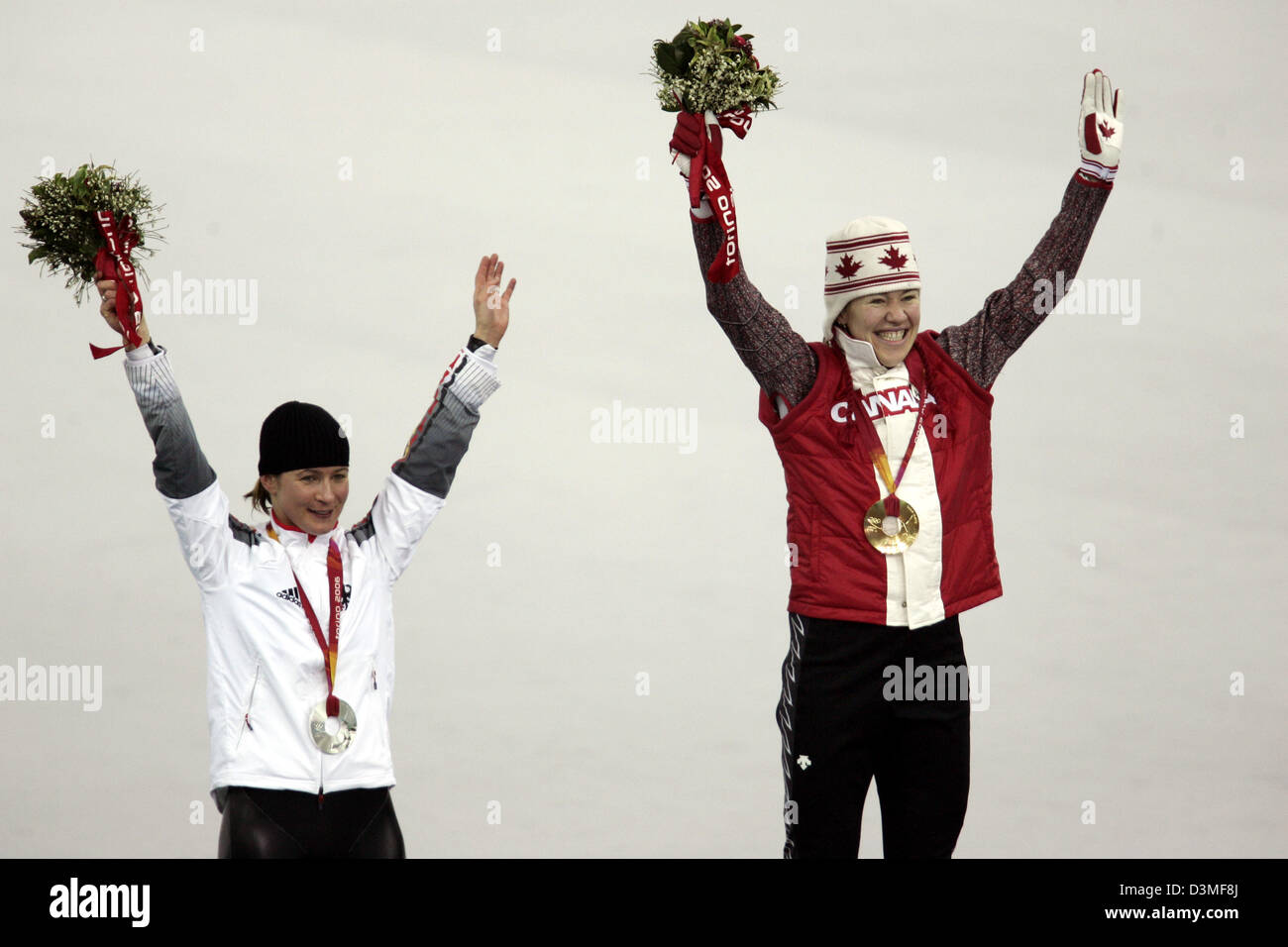 (Afp) - La médaillée d'argent allemand Claudia Pechstein et médaillée d'or canadienne Clara Hughes célébrer sur le podium à la vitesse de la glace patinoire à Turin, Italie, 25 février 2006. Photo : Frank May Banque D'Images