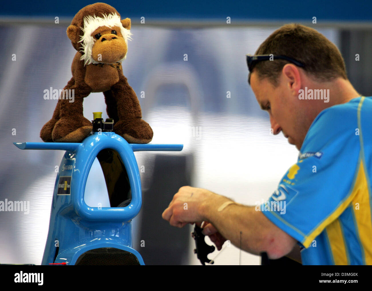Un mécanicien travaille sur la voiture de course de Formule 1 espagnol  Fernando Alonso Champion du Monde avec une peluche de singe assis sur le  dessus de la voiture à la piste