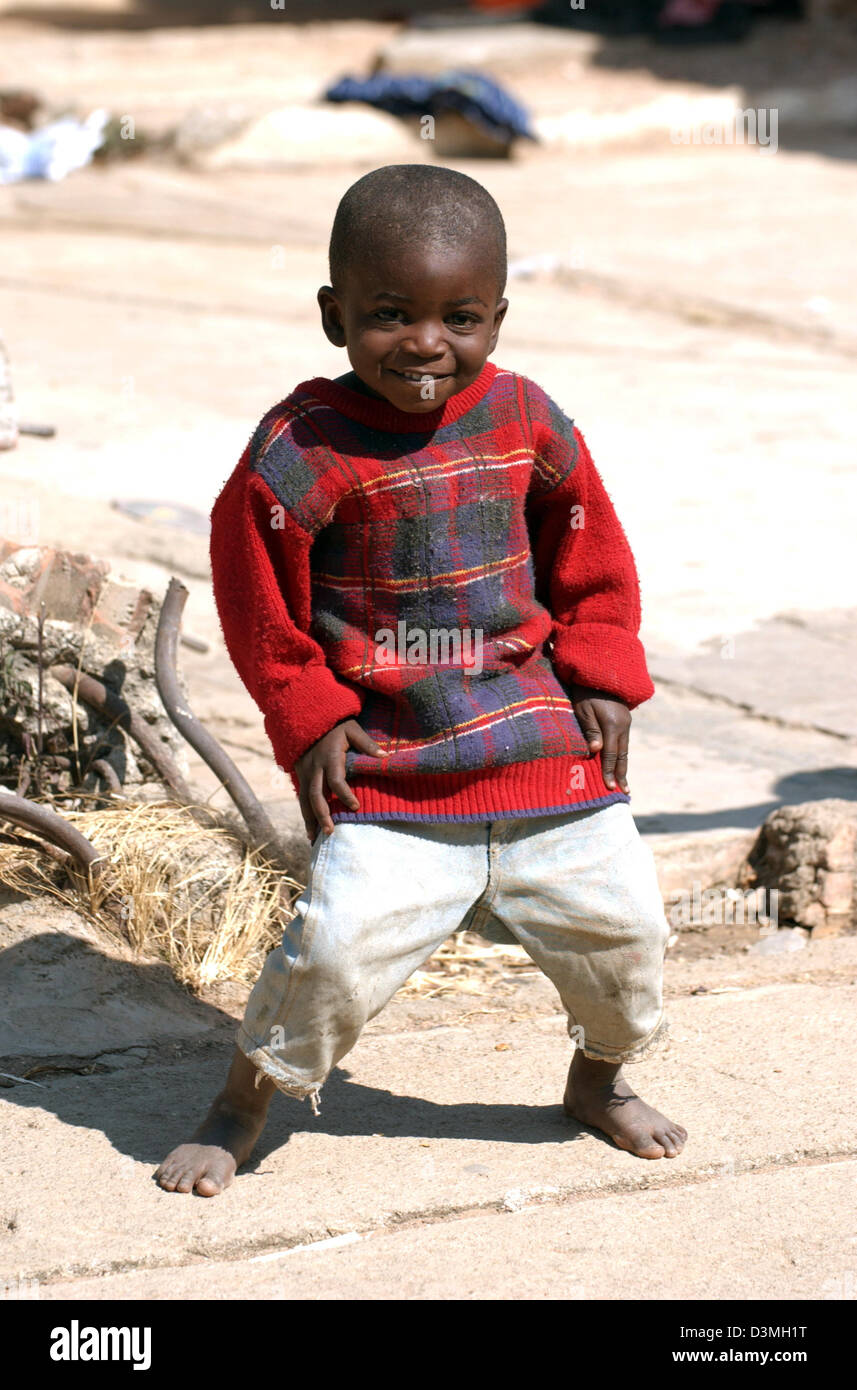 (Afp) - Un jeune garçon se trouve dans un environnement poussiéreux, rue ravagée par la guerre dans la province de Huambo, Angola ville, 21 juillet 2005. Photo : Wolfgang Langenstrassen Banque D'Images