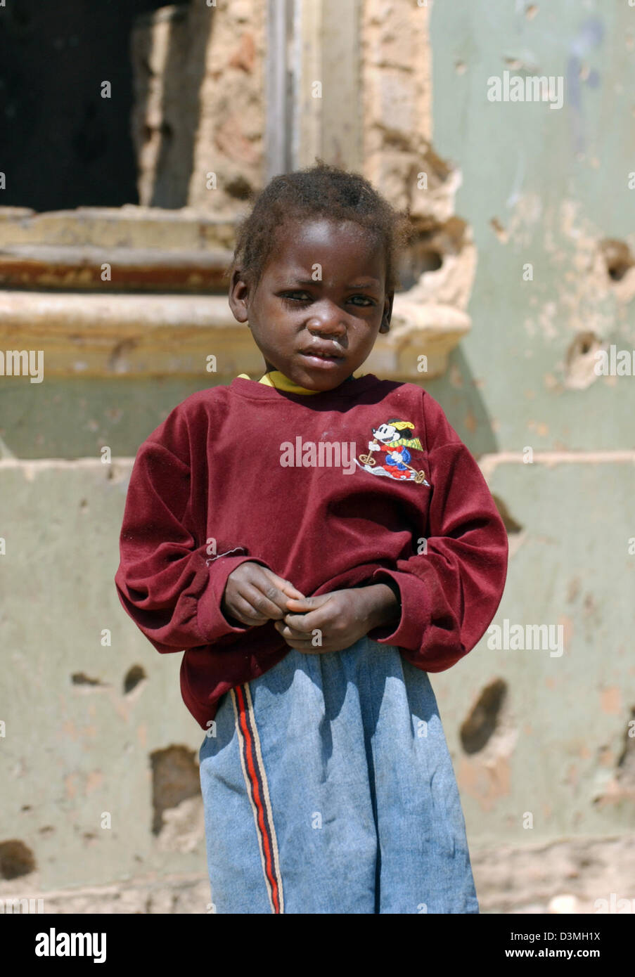 (Afp) - Un jeune garçon se trouve dans un environnement poussiéreux, rue ravagée par la guerre dans la province de Huambo, Angola ville, 21 juillet 2005. Photo : Wolfgang Langenstrassen Banque D'Images