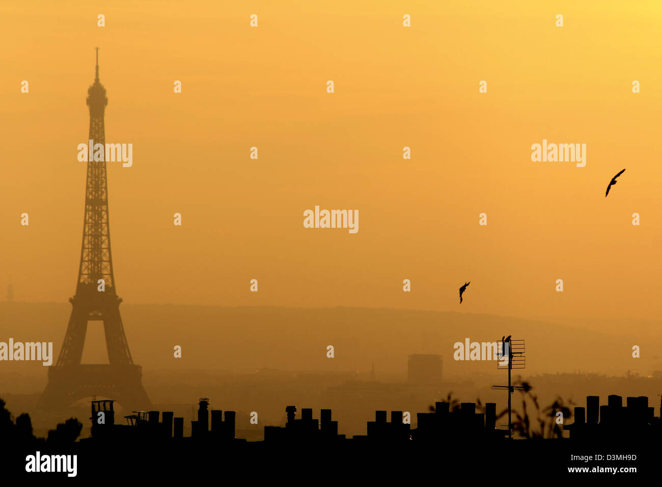 La Tour Eiffel vue de Montmartre sur le coucher du soleil. Silhouette sombre de la tour et toits de Paris contre le ciel rouge naturellement Banque D'Images