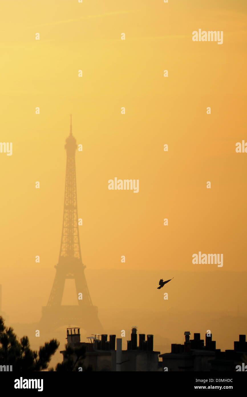 La Tour Eiffel vue de Montmartre sur le coucher du soleil. Silhouette sombre de la tour et toits de Paris contre le ciel rouge naturellement. Banque D'Images