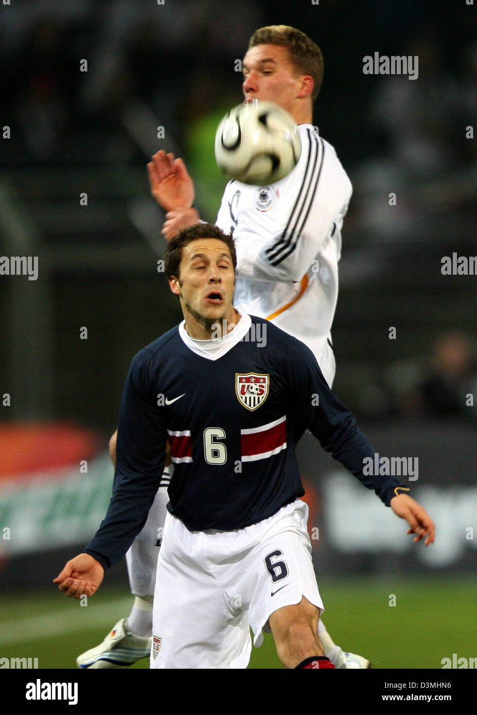 Le joueur de soccer national allemand Lukas Podolski (retour) et Steven Cherundolo américaine lutte pour la balle durant le match amical au stade Signal Iduna Park de Dortmund, Allemagne, mercredi, 22 mars 2006. L'Allemagne a remporté le match 4-1. Photo : Franz-Peter Tschauner Banque D'Images