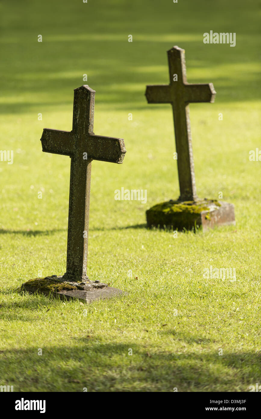 Deux vieilles tombes avec des croix chrétiennes sur l'herbe verte du cimetière Banque D'Images