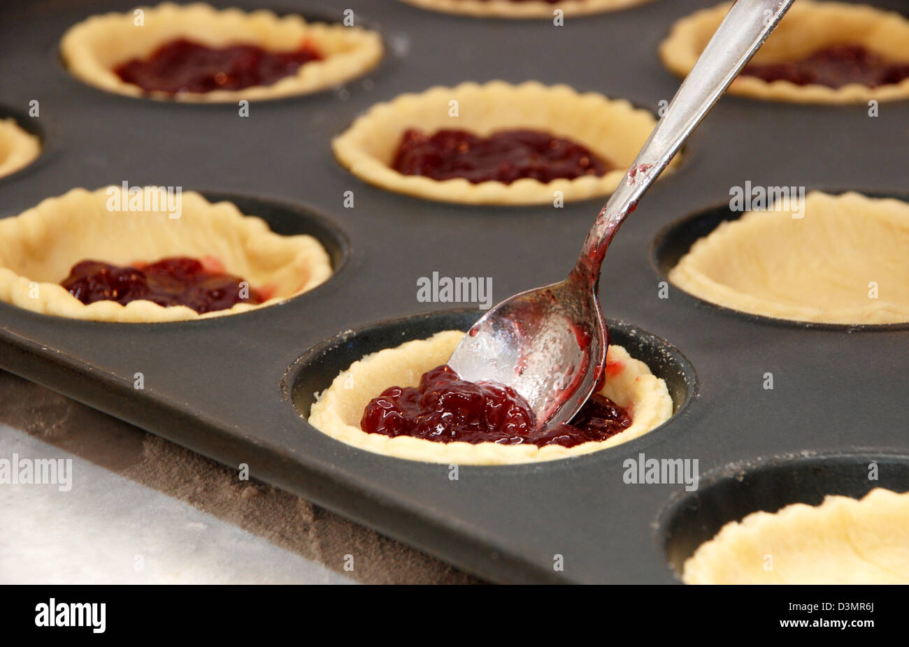 Libre de tartelettes à la confiture d'être remplies avec une cuillère en métal Banque D'Images
