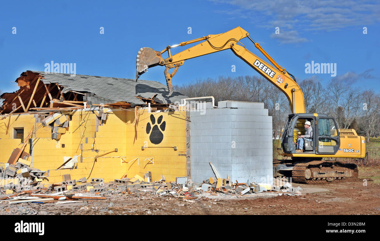 Une dépanneuse lourde démonte le vestiaire d'un stade de football à Madison CT USA comme la ville se prépare à construire une nouvelle. Banque D'Images