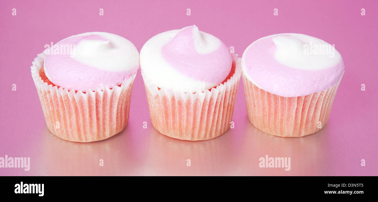 Cupcakes rose trois dans une rangée Banque D'Images