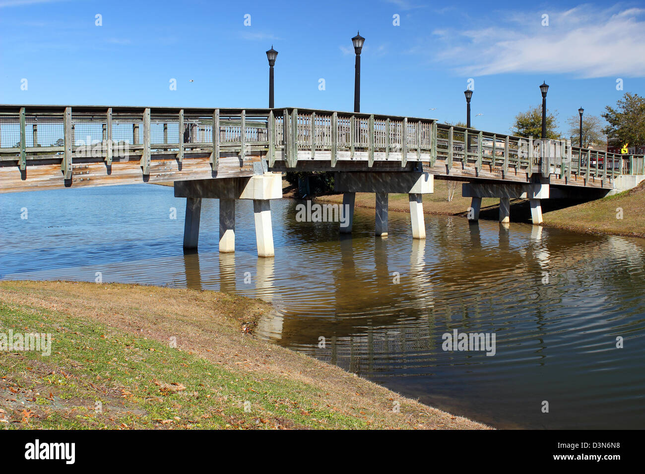 Une petite passerelle pour traverser un étang dans un parc sur une journée ensoleillée. Banque D'Images