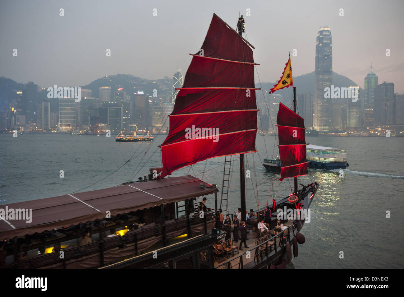 Une croisière dans le port sur l'Aqua Luna est très populaire avec les touristes. Au coucher du soleil l'horizon de Hong Kong est aussi spectaculaire que jamais. Banque D'Images