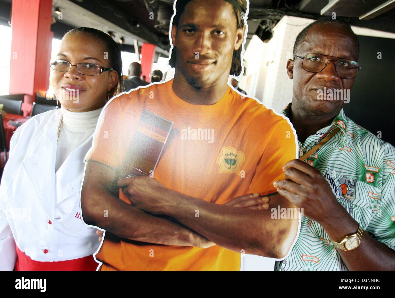 Clotilde et Albert Drogba se tenir dans un restaurant à côté d'une affiche de la taille de leur fils, avant de classe mondiale de Didier Drogba de la Côte d'Ivoire, à Hambourg, Allemagne, le jeudi, 08 juin 2006. Côte d'Ivoire jouera l'Argentine samedi prochain à Hambourg. Photo : Kay Nietfeld Banque D'Images