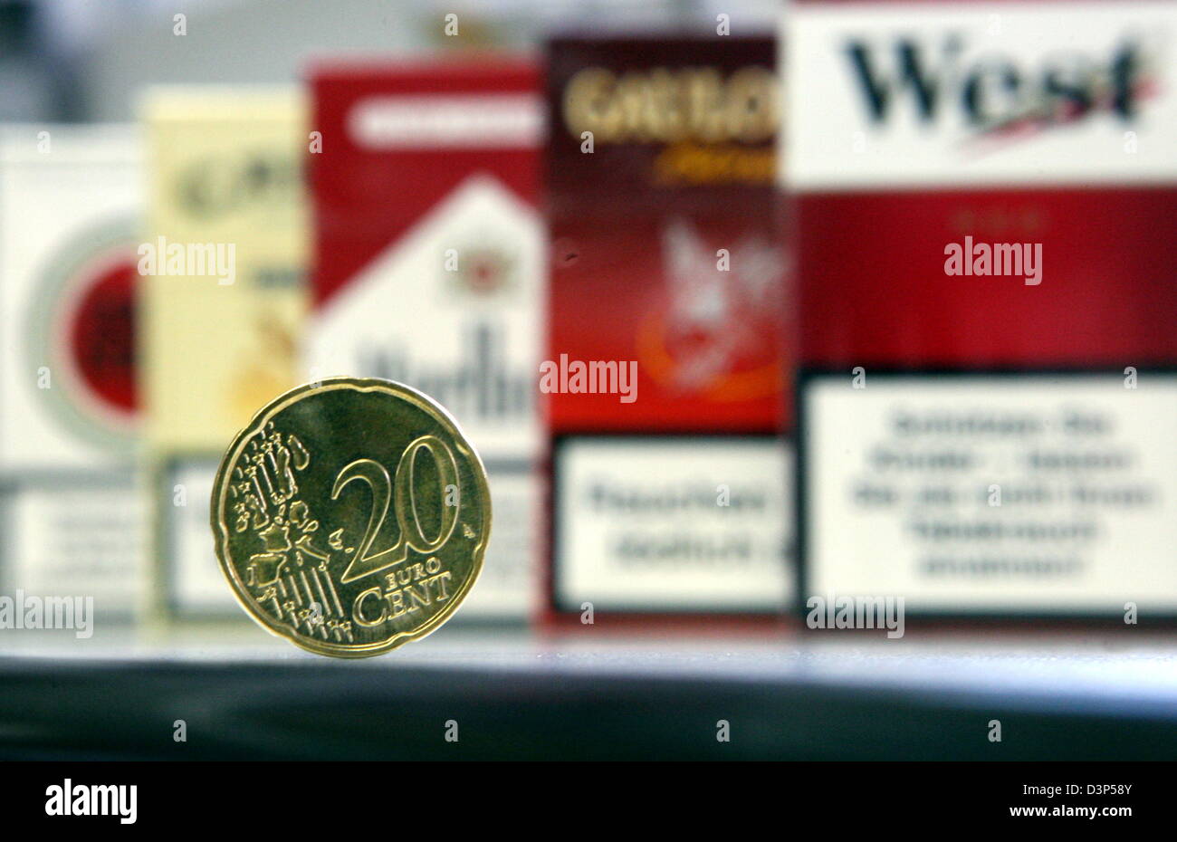 L'image montre une pièce de 20 cents en face de paquets de cigarettes dans un magasin de tabac à Hambourg, Allemagne, le mercredi 06 septembre 2006. Les porte-parole des grandes compagnies de tabac dans les deux de Munich et Hambourg a annoncé que les fumeurs vont payer un supplément de 20 cents par paquet pour la plupart des marques à partir du 01 octobre, en raison d'une augmentation de la taxe sur la valeur ajoutée. Photo : Kay Nietfeld Banque D'Images