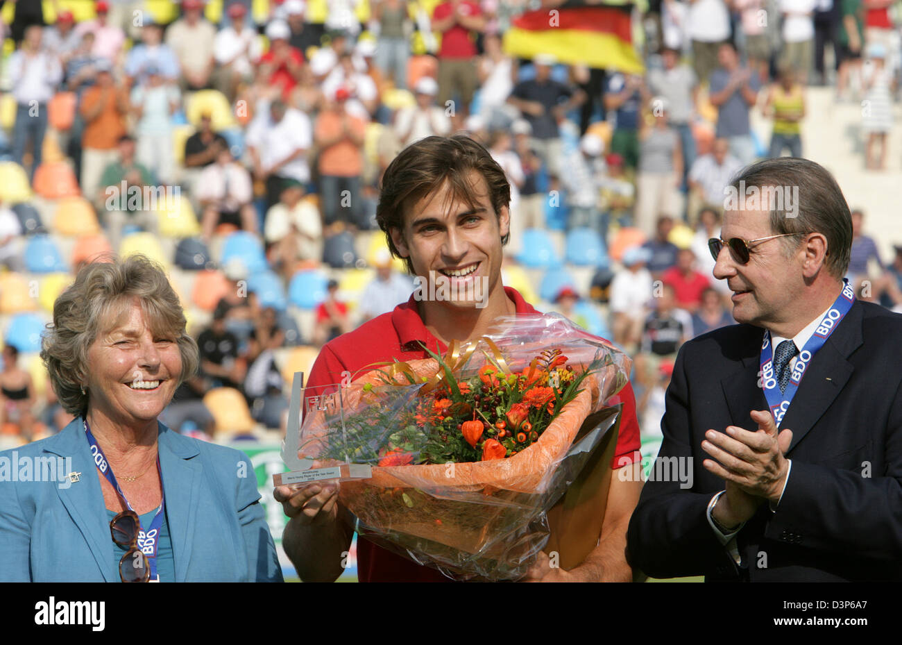 Président du Comité International Olympique (CIO) Jacques Rogge (L) et président de la Fédération Internationale de Hockey Els van Breda Vriesman (R) félicite les meilleurs du monde hockey player Teun de Nooijer (C) des Pays-Bas, en Allemagne, Moenchengladbach, samedi 16 septembre 2006. Photo : Achim Scheidemann Banque D'Images