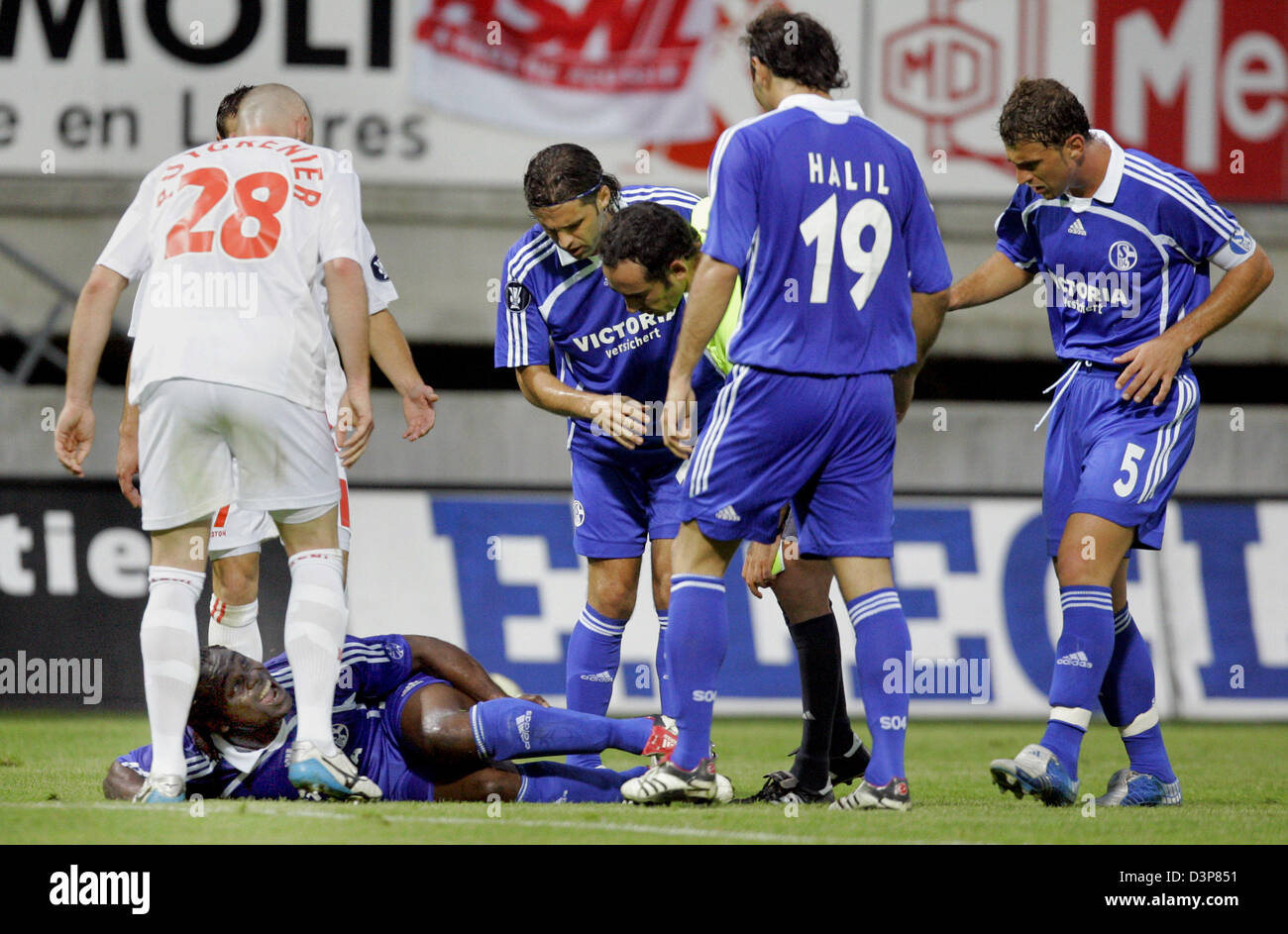 Gerald Asamoah, Schalke est entouré de ses coéquipiers et de Nancy Sébastien Puygrenier (L) après une faute moyenne dans la coupe de l'UEFA prelim comparaison comme Nancy Lorraine vs FC Schalke 04 à Nancy, France, jeudi, 28 septembre 2006. Asamoah a brisé son tibia et des jambes. Schalke a été battu 1-3 à défaut d'aller jusqu'à la phase de groupes. Photo : Bernd Thissen Banque D'Images