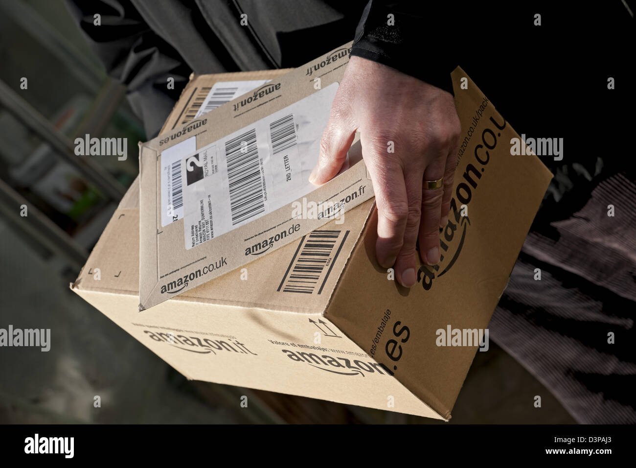 Gros plan de l'homme personne transportant et livrant Amazon box Internet shopping colis livraison Angleterre Royaume-Uni Grande-Bretagne Banque D'Images