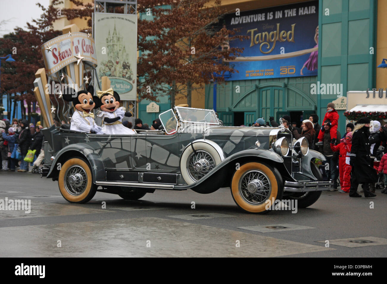 Mickey et Minnie Mouse à l'arrière d'une voiture pendant un défilé en hiver au parc Walt Disney Studios, Disneyland Paris. Banque D'Images