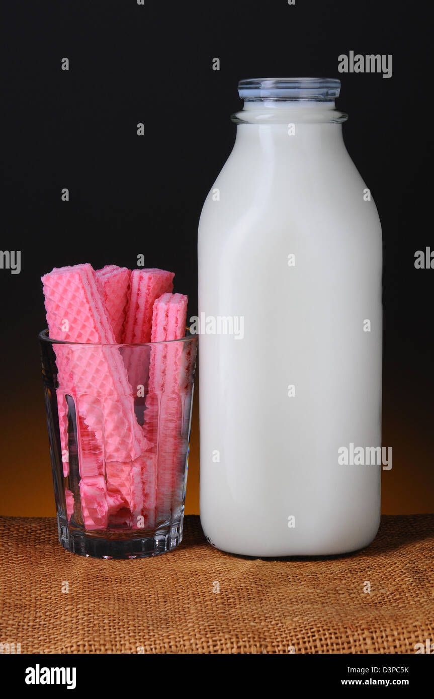 Libre d'une ancienne bouteille de lait en verre et un verre rempli de gaufrettes, sucre rose Banque D'Images