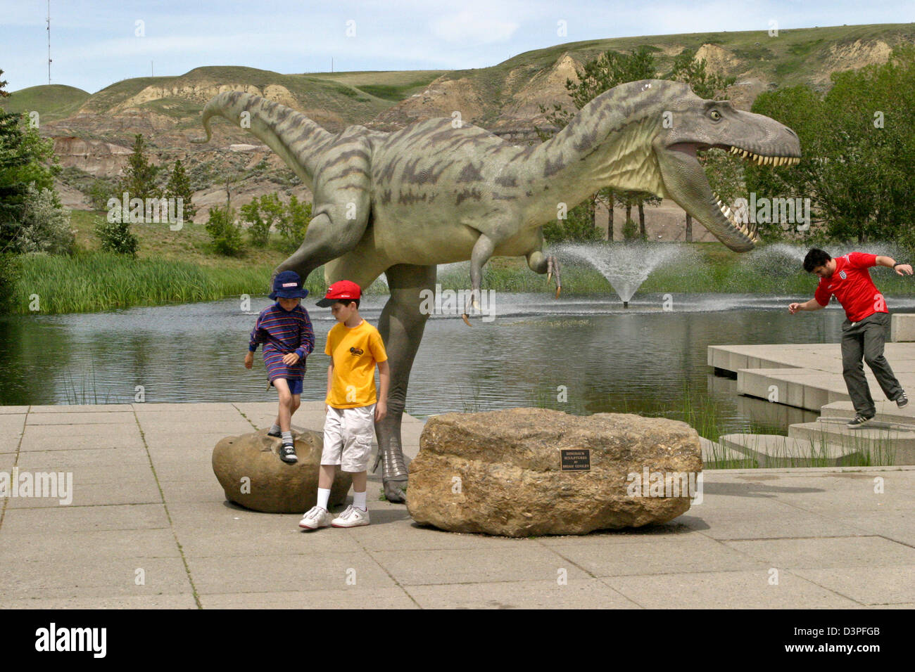 Les garçons jouent à côté de l'Albertosaurus au Royal Tyrrel Museum de Drumheller, Alberta, Canada Banque D'Images