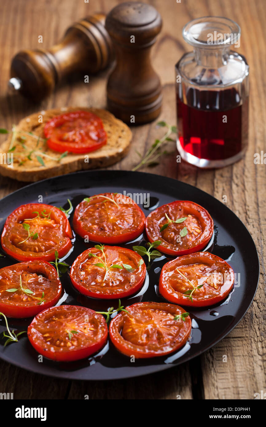 Les tomates cuites au four avec des herbes et d'huile d'olive Banque D'Images