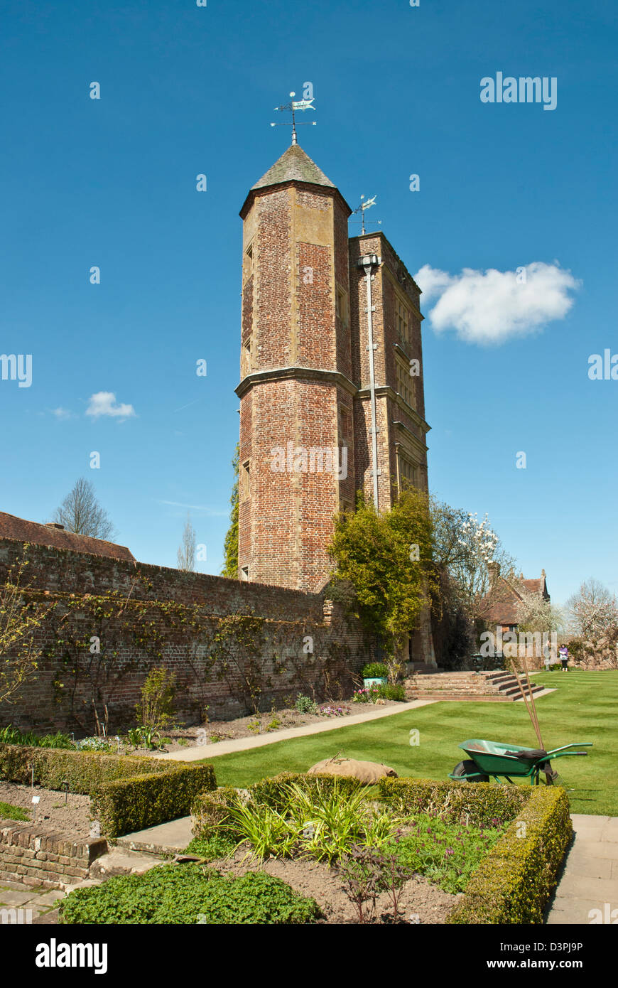 Tour élisabéthaine Sissinghurst et pelouse tour au printemps, journée ensoleillée, avec des jardiniers brouette et la plantation. Banque D'Images