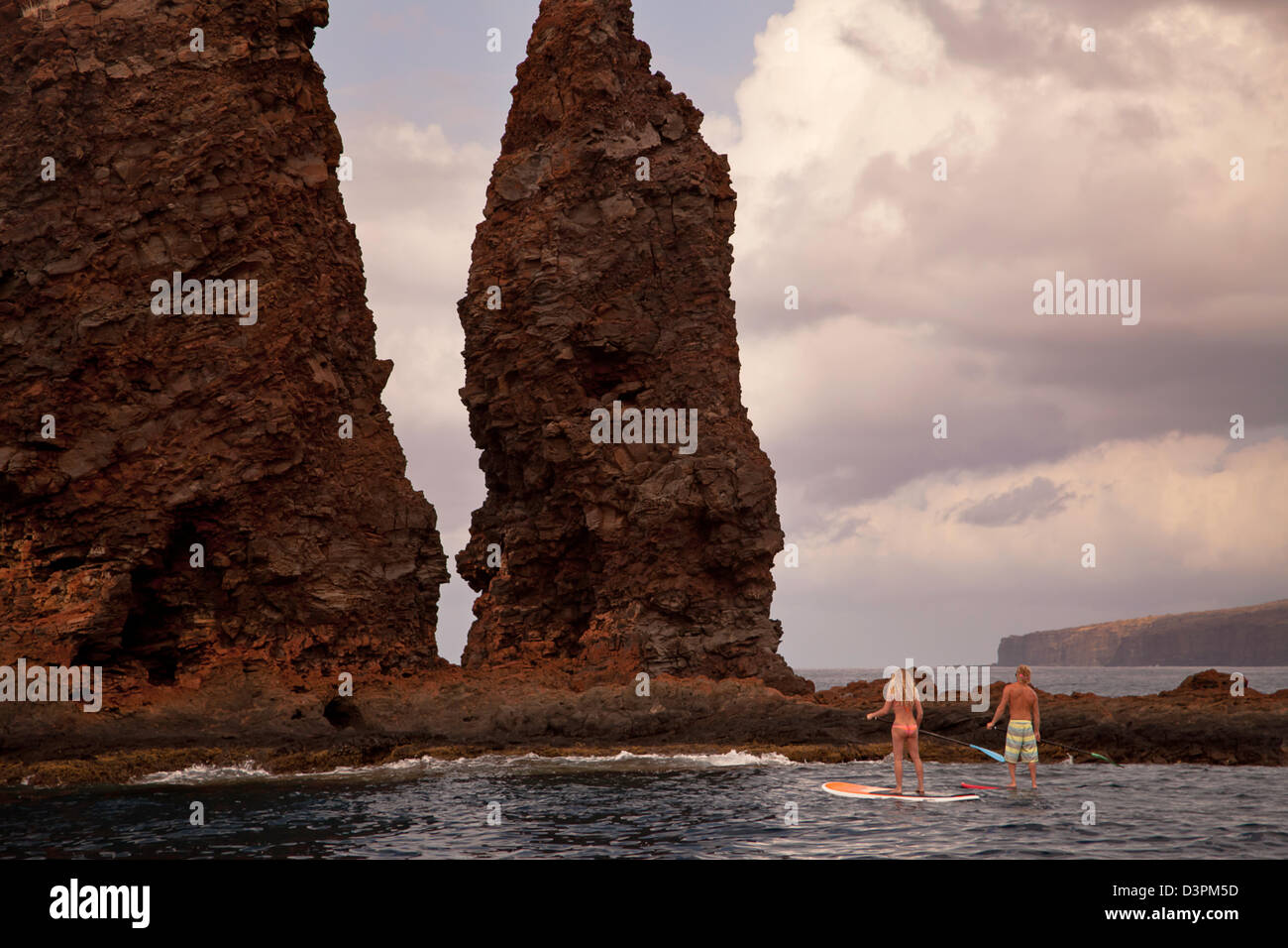 Un couple sur le stand-up paddle boards à aiguilles à l'extérieur de l'île de Lanai, Hawaii. Les deux sont libérés du modèle. Banque D'Images