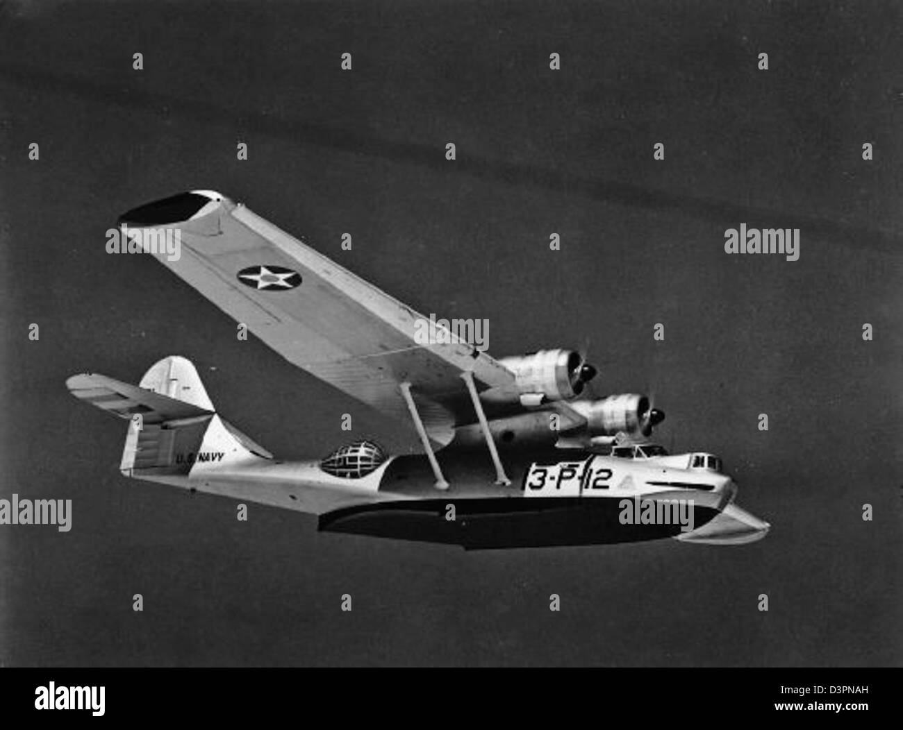 Cette photographie montre le PBY-4 Catalina, un hydravion utilisé pendant la seconde Guerre mondiale, survolant une île du Pacifique Nord. Le PBY-4 était crucial dans la reconnaissance et la guerre anti-sous-marine. Banque D'Images